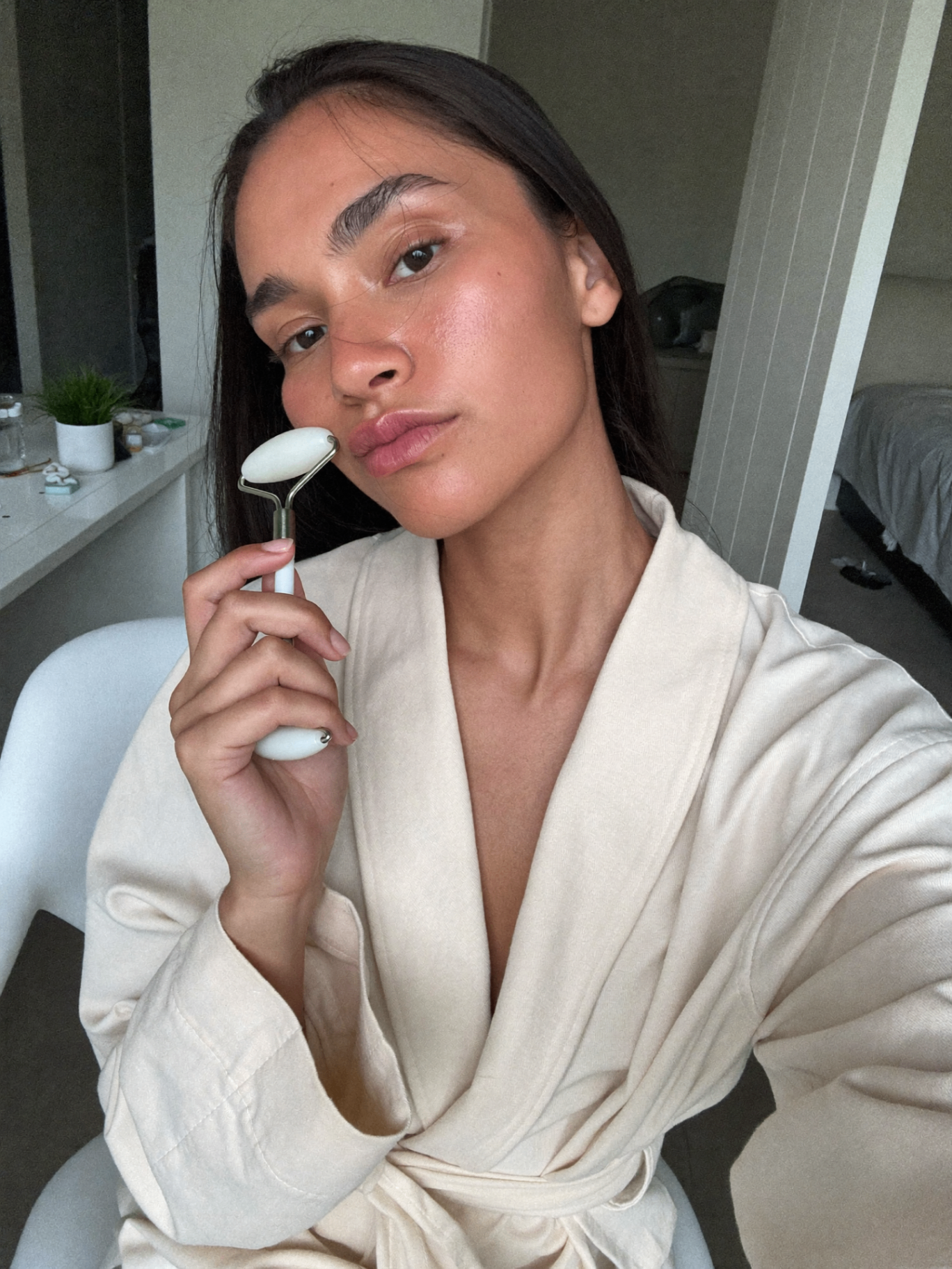 Aquamarine gua sha stone gliding along the jawline